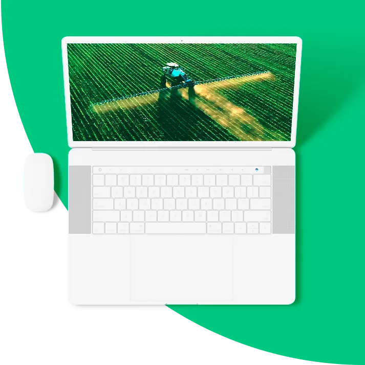 Laptop felülnézetből, a képernyőn zöld táblát permetező traktor