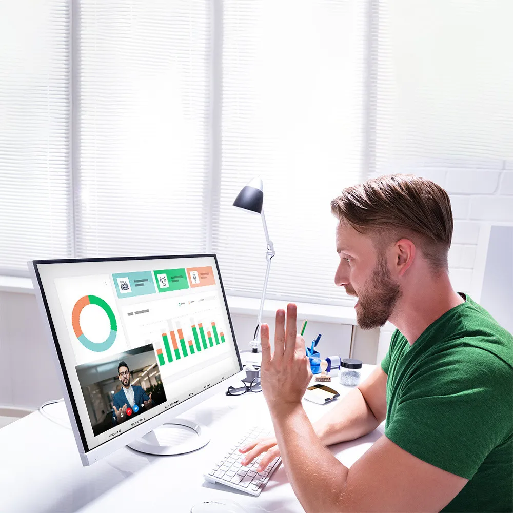 Ingyenes online konzultáció: férfi videohívásban beszél egy szakértővel, a monitoron grafikonok