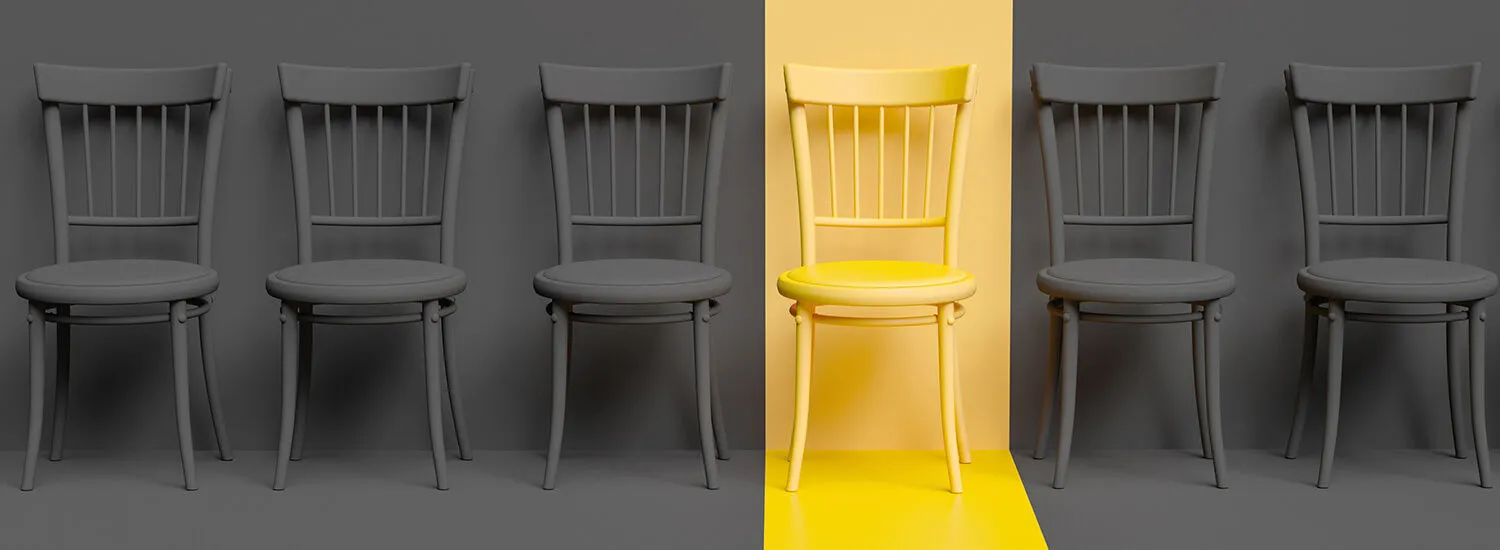 Row of grey chairs with a single yellow chair standing out