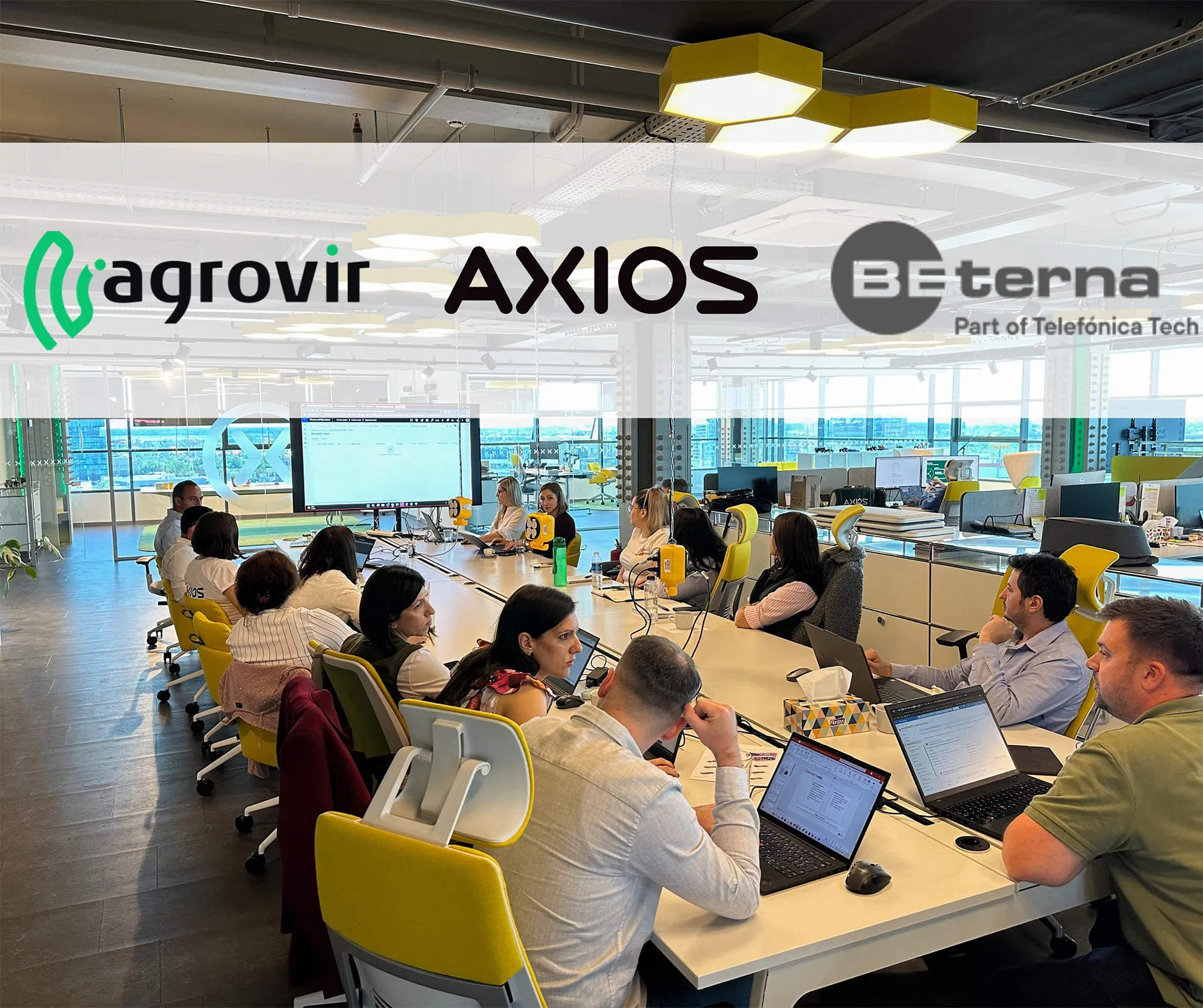 Az AgroVIR, az AXIOS és a BE-terna logója egy irodai csapatmegbeszélés fotóján